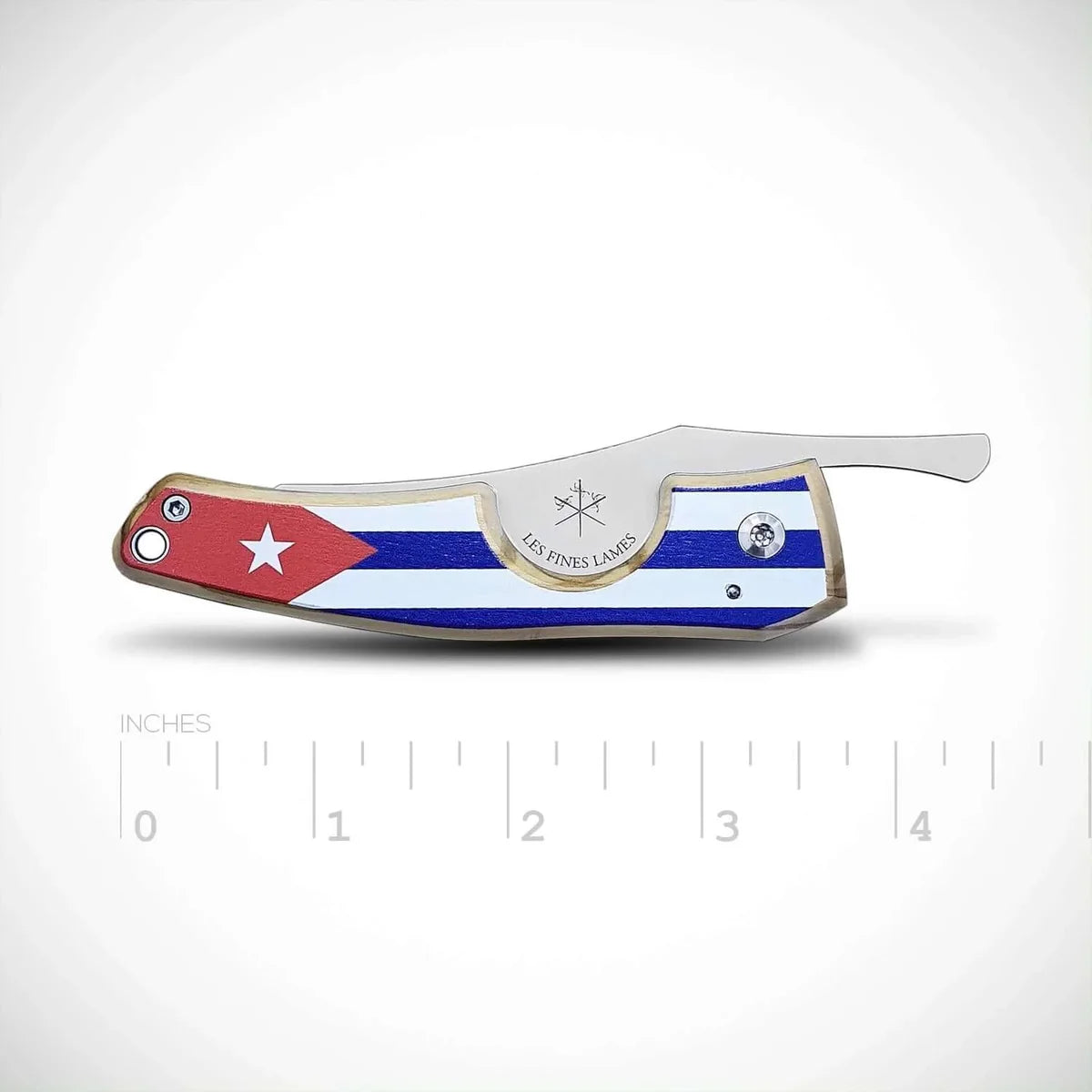 A folding pocket knife with a Cuban flag design on the handle, shown open against a light gray background with a small inch ruler below for scale.