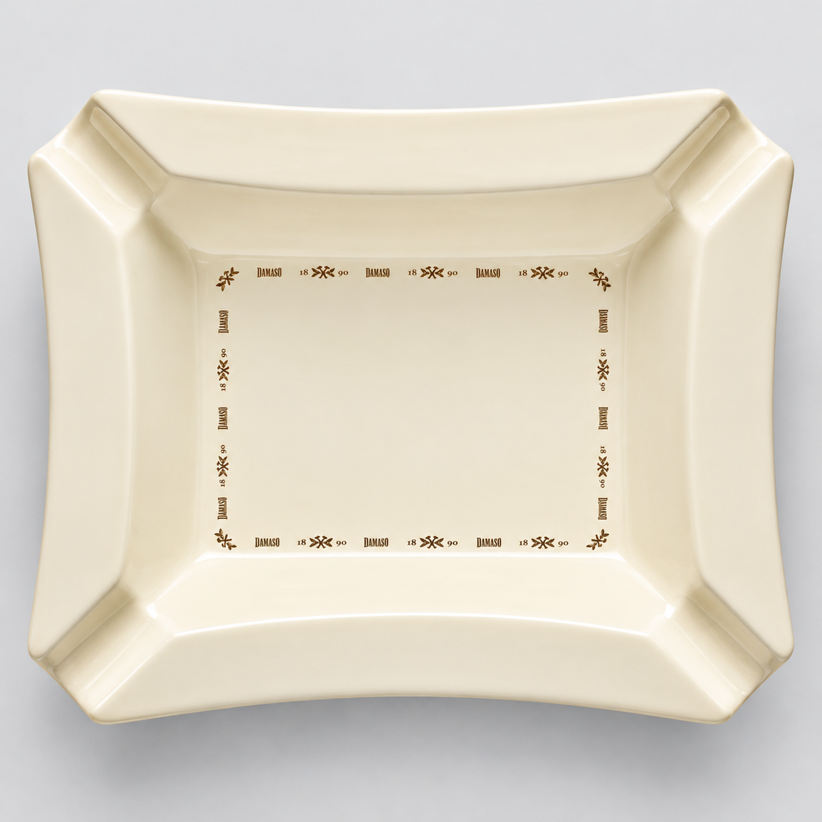 An off-white ceramic serving platter with a brown decorative border, photographed from directly above on a neutral gray background.