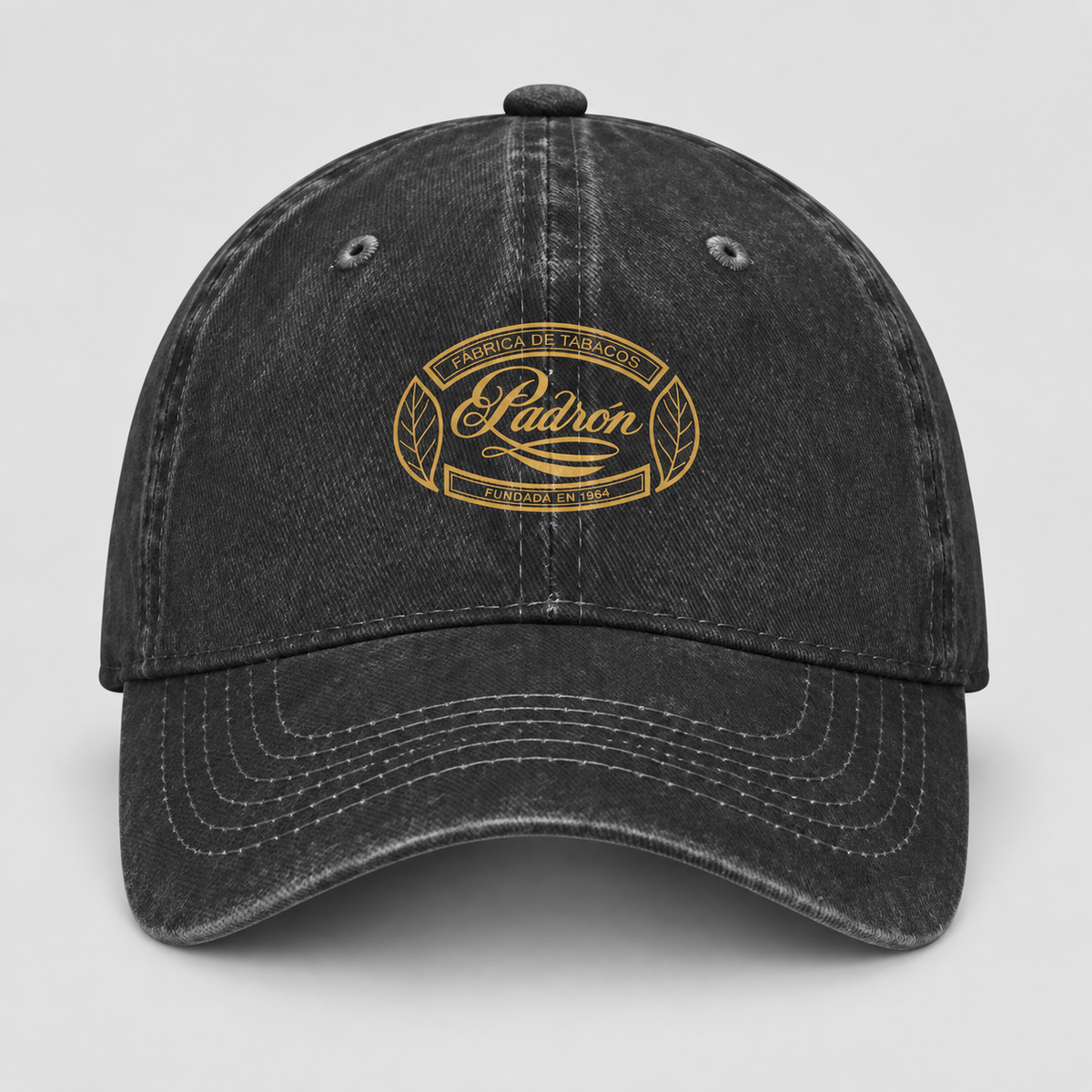 A black washed baseball cap with a gold embroidered oval logo on the front that reads 'Madron Family Farm' and 'Falcone & Smith'.