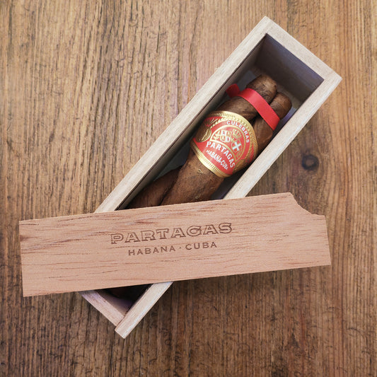 Partagas cigar in a wooden box on a wooden surface