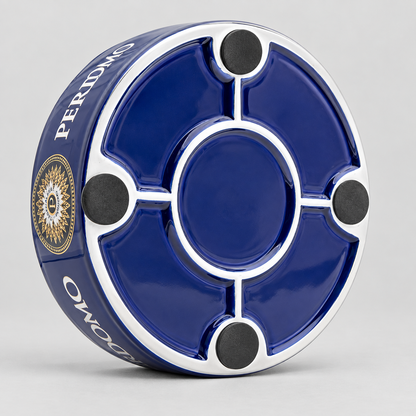 A circular blue and white ceramic ashtray with four black rubber feet, shown on a light gray background. The side of the ashtray features the brand name 'PERIDMO' in white text alongside a gold and black emblem.