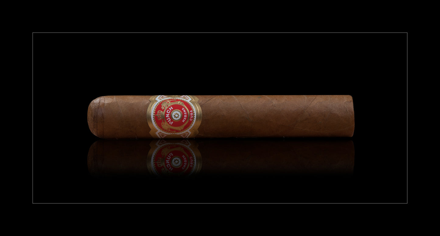 A single brown cigar with a red and gold band, displayed horizontally against a black background with a subtle reflection below.