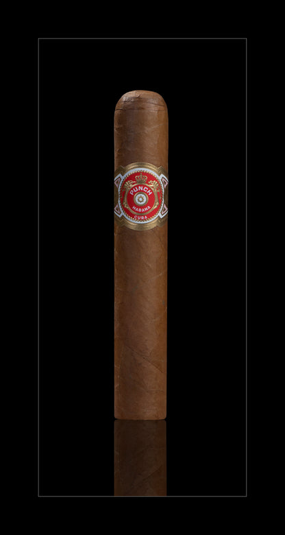 A single brown cigar with a red and gold band, centered on a black background with a subtle reflection below.