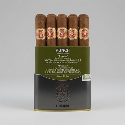 Five cigars in a branded display pack against a light gray studio background. The cigars are medium brown with gold and red bands, and the packaging is olive green and dark gray with gold trim.