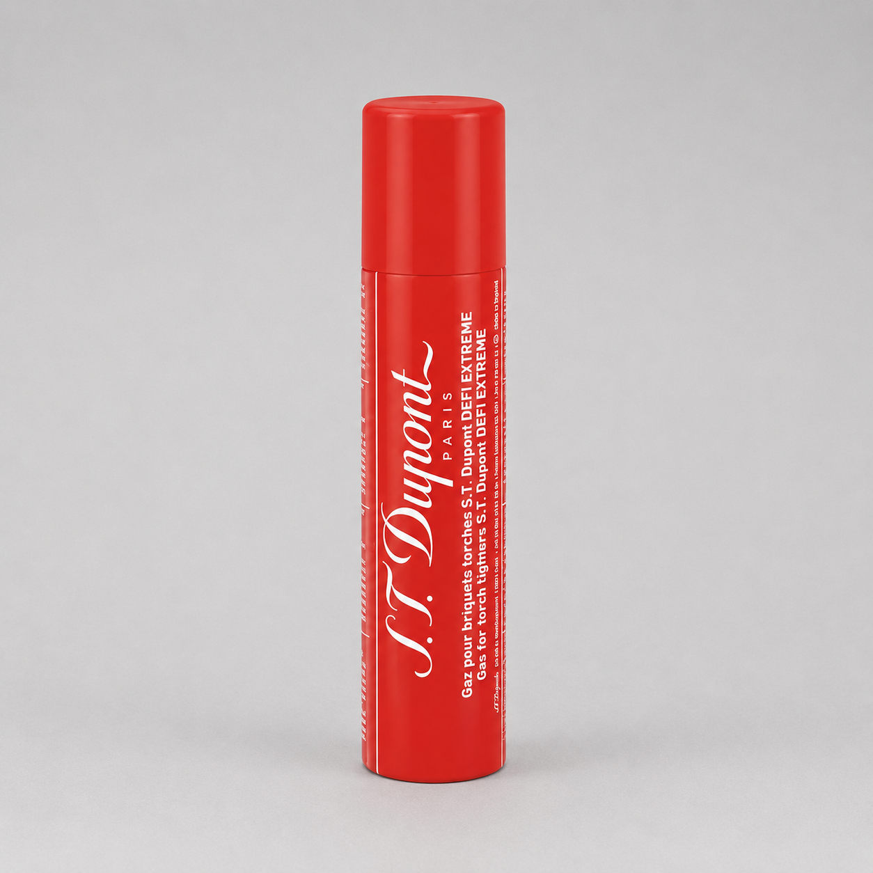 A red cylindrical tube of S.T. Dupont St. Extreme lip balm with white text, standing upright on a light gray background.
