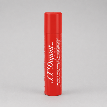 A red cylindrical tube of S.T. Dupont St. Extreme lip balm with white text, standing upright on a light gray background.