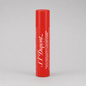 A red cylindrical tube of S.T. Dupont St. Extreme lip balm with white text, standing upright on a light gray background.