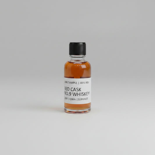 Small bottle of RED CASK NO.9 whiskey with a label on a light pink background