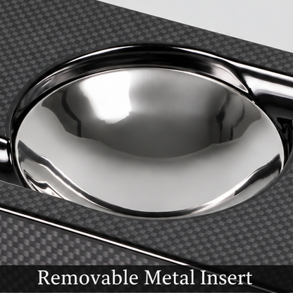 A rectangular black carbon fiber ashtray with a glossy silver metallic bowl in the center, photographed on a light gray background.