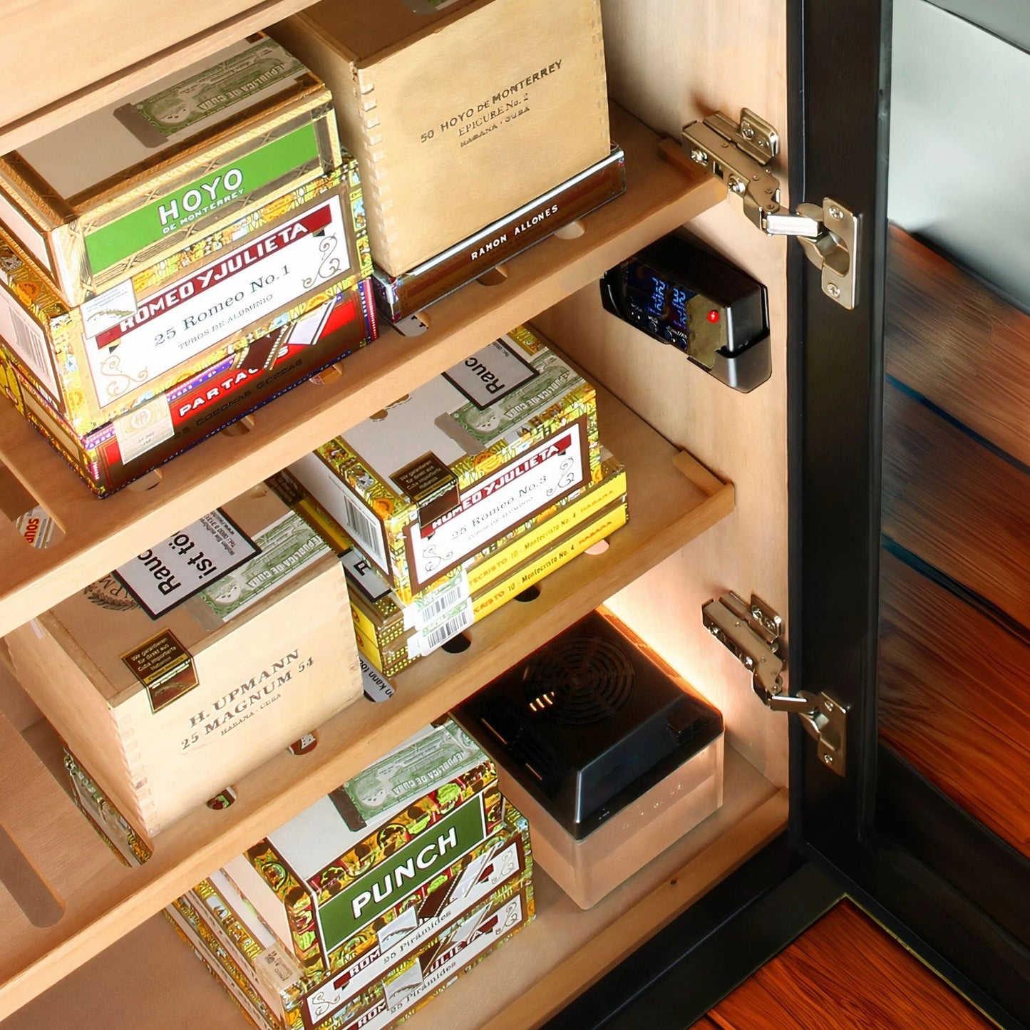 Cigar humidor with various cigars and a digital hygrometer.