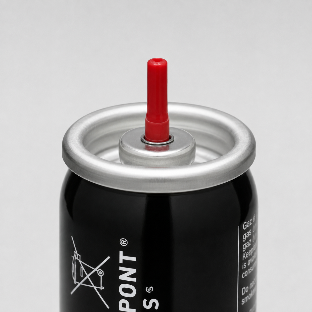 Close-up of a black aerosol can with a silver metal top and a bright red nozzle tip, photographed on a light gray background. Part of the white PONT brand text is visible on the can.
