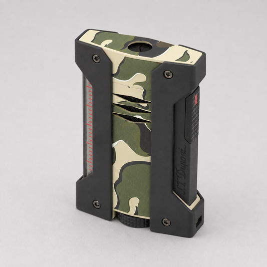 A compact ST DUPONT LIGHTER with a green, beige, and black camouflage pattern on the outer body, featuring black protective side frames and a textured grip at the base, shown on a neutral gray background.