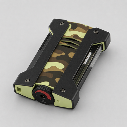 A rugged rectangular device with a black and olive green camouflage pattern, featuring a textured dial with a red ring on the front, photographed on a neutral light gray background.