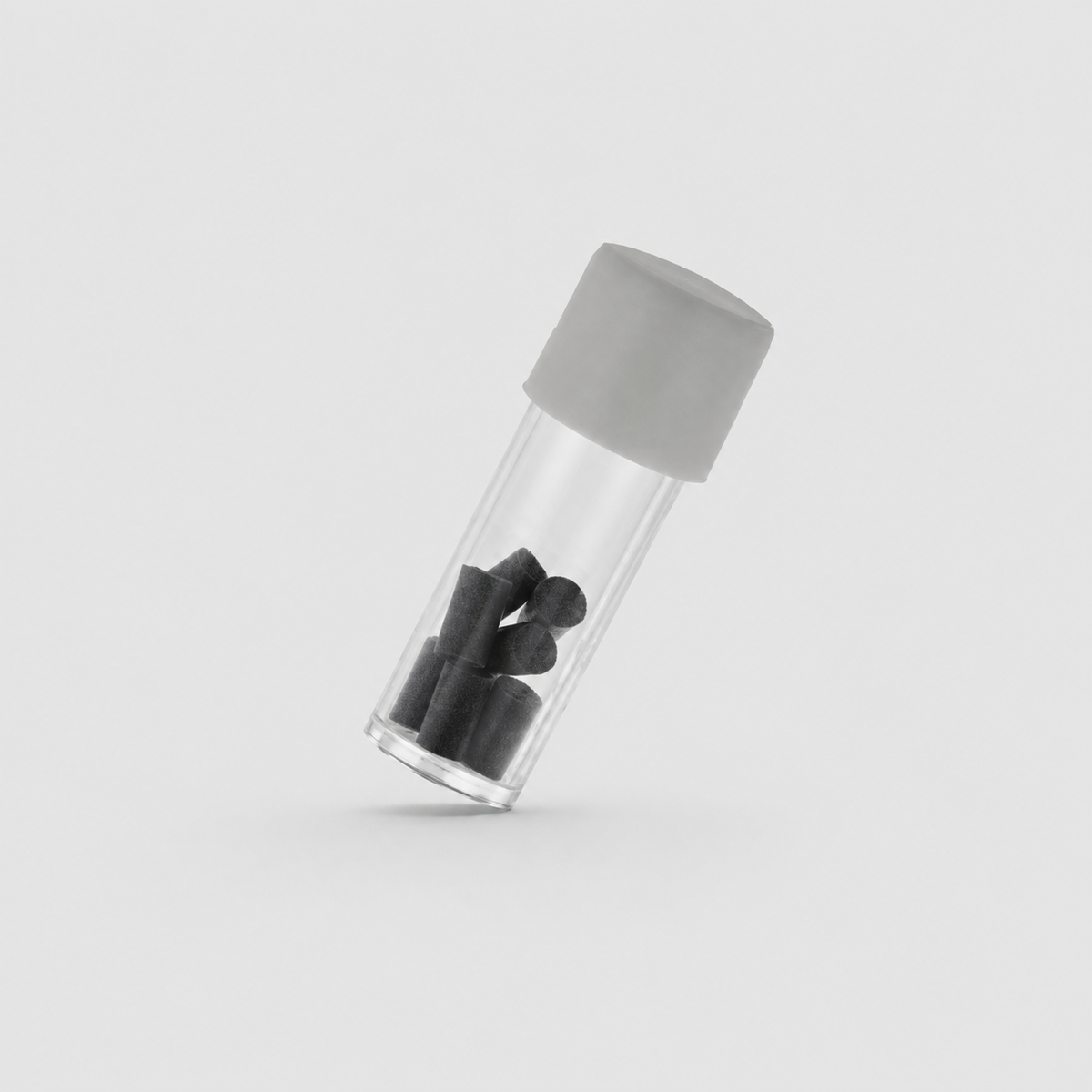 A clear cylindrical vial with a matte gray screw cap, shown at an angle on a light gray background. Inside the vial are several dark gray to black cylindrical pieces.
