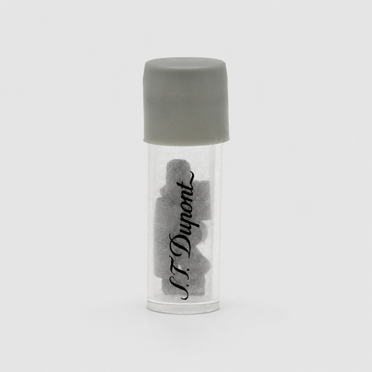 A small clear cylindrical vial with a gray screw cap, containing several dark gray irregular pieces, with the brand name 'N.F.