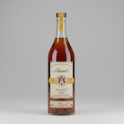 A bottle of Shenk's Kentucky Bourbon Whiskey, 2021, showing the amber liquid and cream label against a neutral gray background.