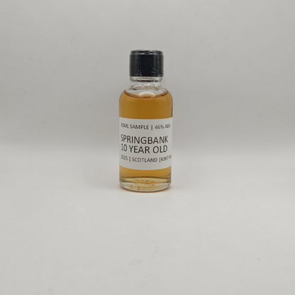 Small bottle of Springbank 10 Year Old whisky sample on a gray background