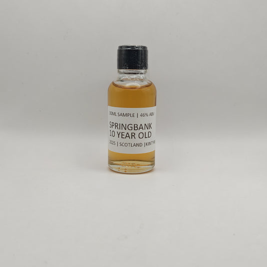 Small bottle of Springbank 10 Year Old whisky sample on a gray background