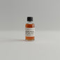 Small bottle of Maker's Mark bourbon on a white surface with a textured gray background