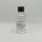 Small glass bottle of Sunset Very Strong Rum with a black cap on a gray background