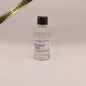 Tequila Ocho bottle with a black cap on a light pink background