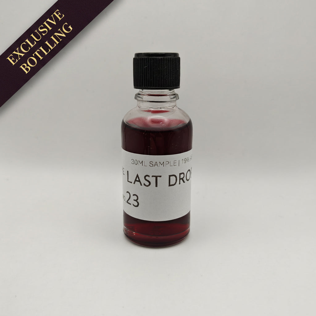 Small bottle with red liquid and a black cap on a white background, featuring 'The Last Drop' branding.