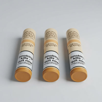 Three Corona Majors cigar tubes arranged in a row on a light gray background. Each tube has a beige cap and base, a white label with black text reading 'Smoking kills quit now', and a yellow-orange balm visible at the bottom.