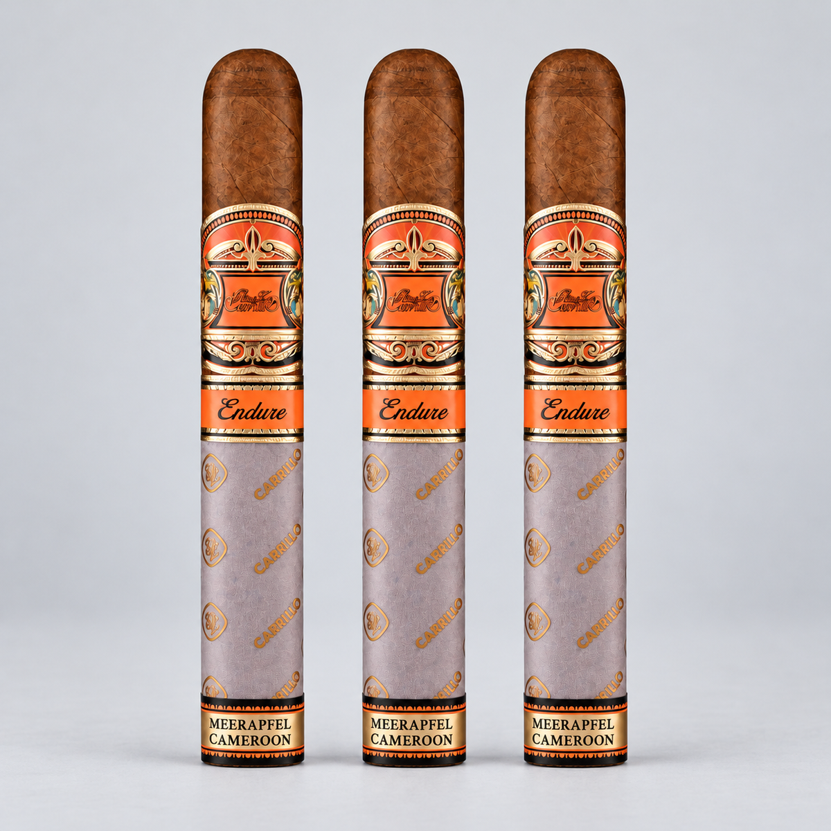 Three cigar tubes standing upright on a light gray background. The tubes are light gray with gold and orange decorative bands and the brand name 'Endure' is visible on the orange bands.
