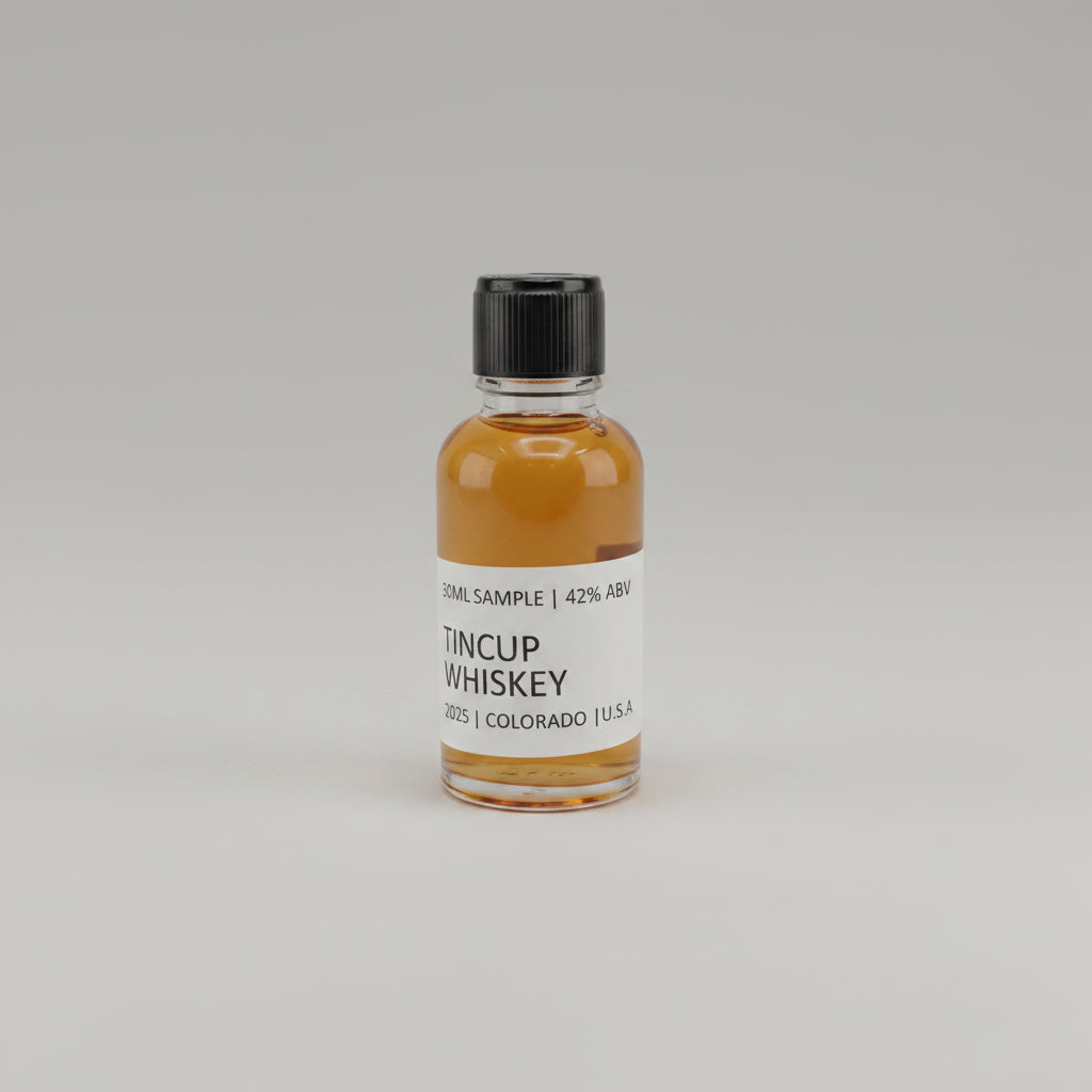 Small bottle of Tincup Whiskey on a light pink background