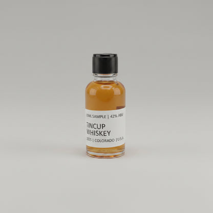 Small bottle of Tincup Whiskey on a light pink background