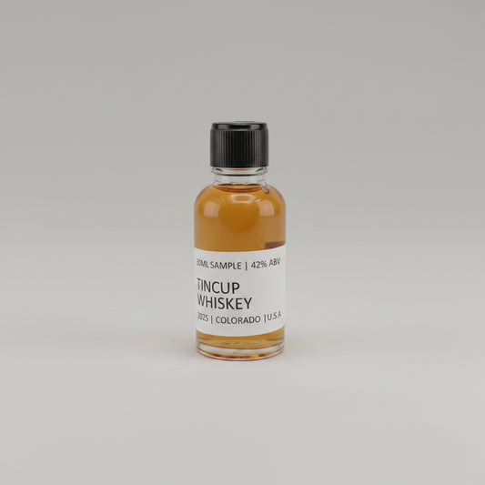 Small bottle of Tincup Whiskey on a light pink background