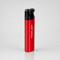 A TorJet portable torch lighter with a metallic red body and a black top ignition cap, standing upright on a light gray reflective surface.