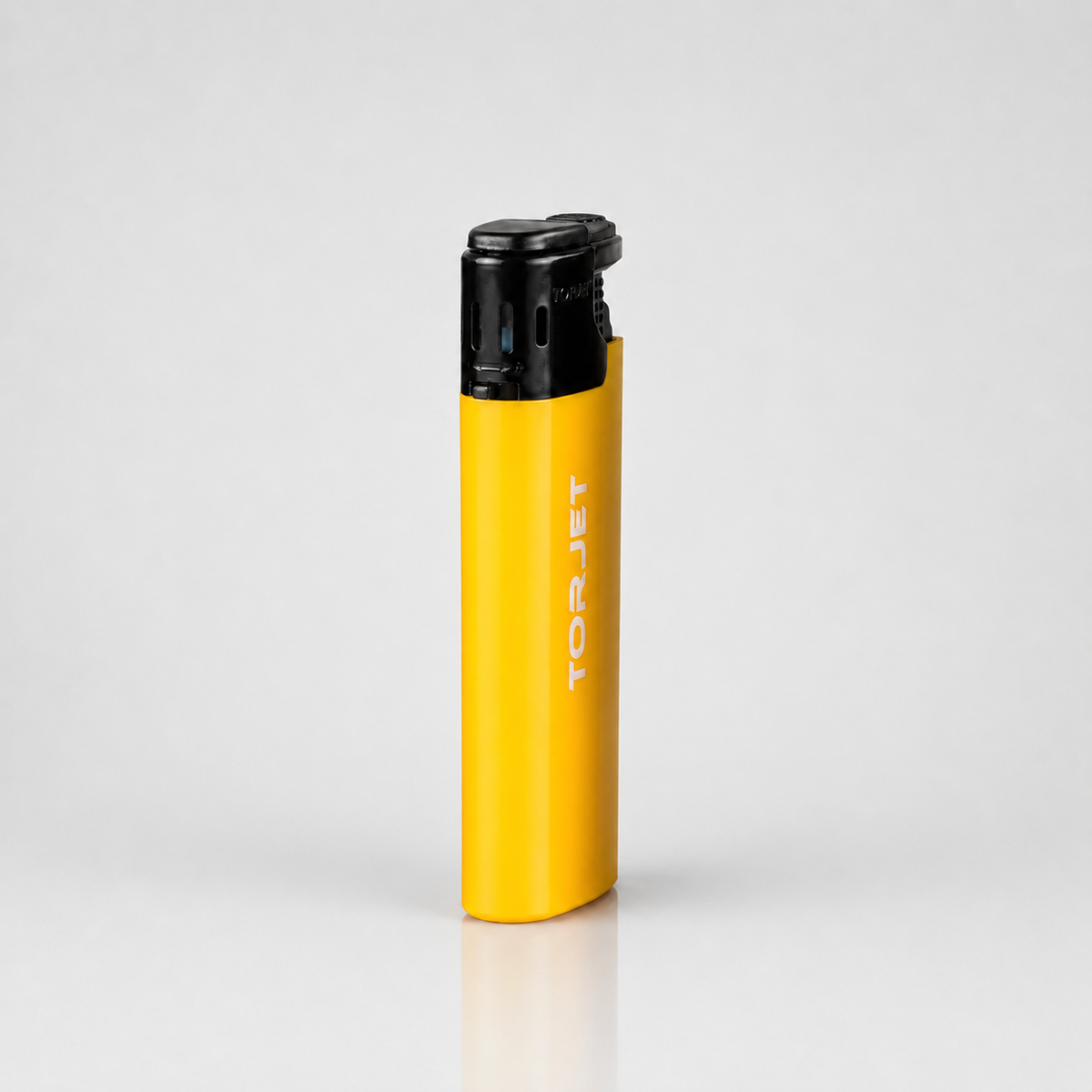 A yellow TORJET portable torch lighter with a black top cap, standing upright on a light gray reflective surface.