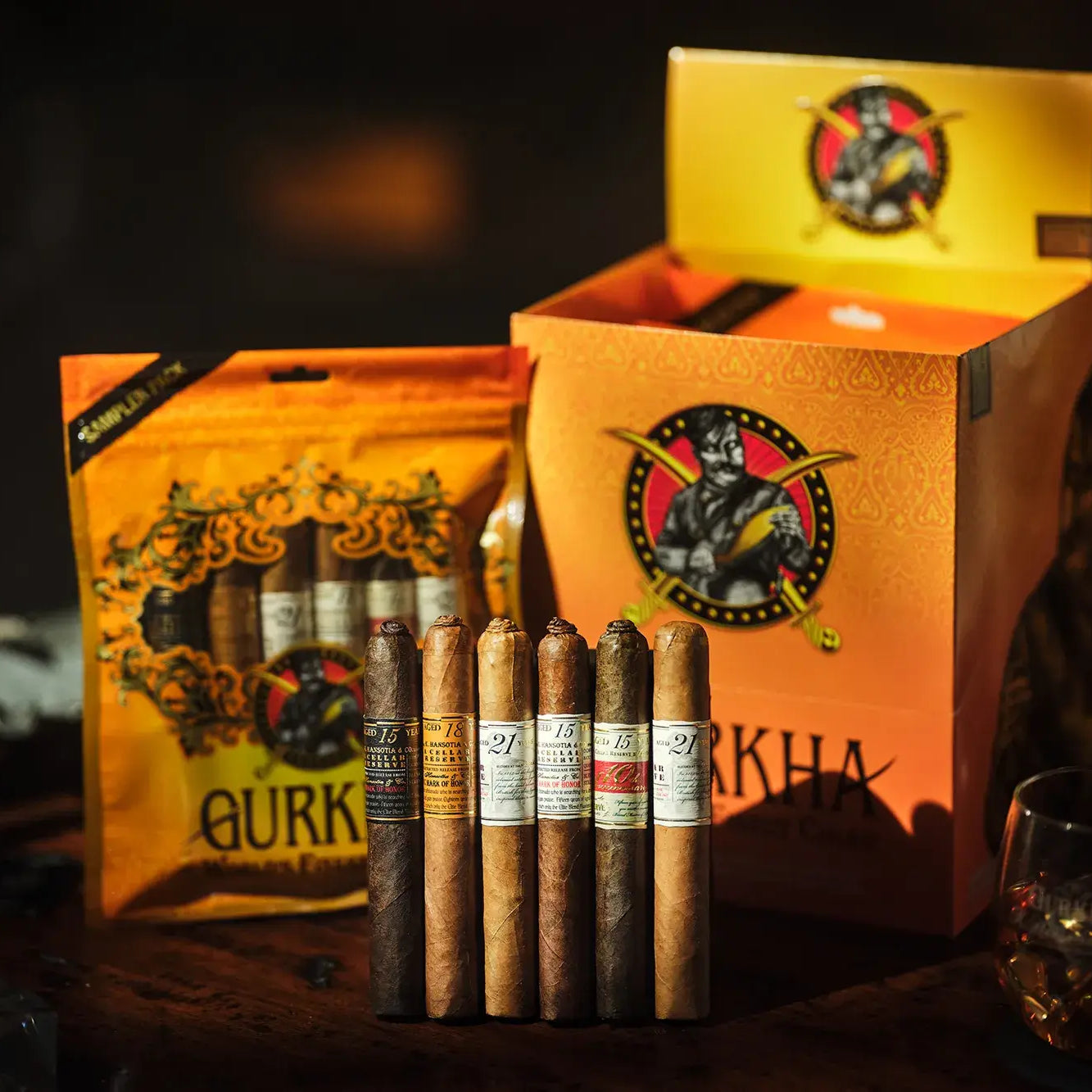 Qurk cigars with packaging and a glass of whiskey on a dark background