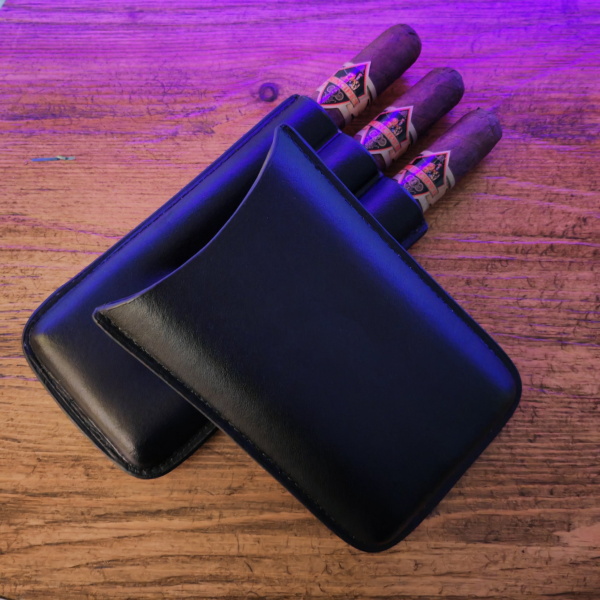 Black leather cigar case with cigars on a wooden surface