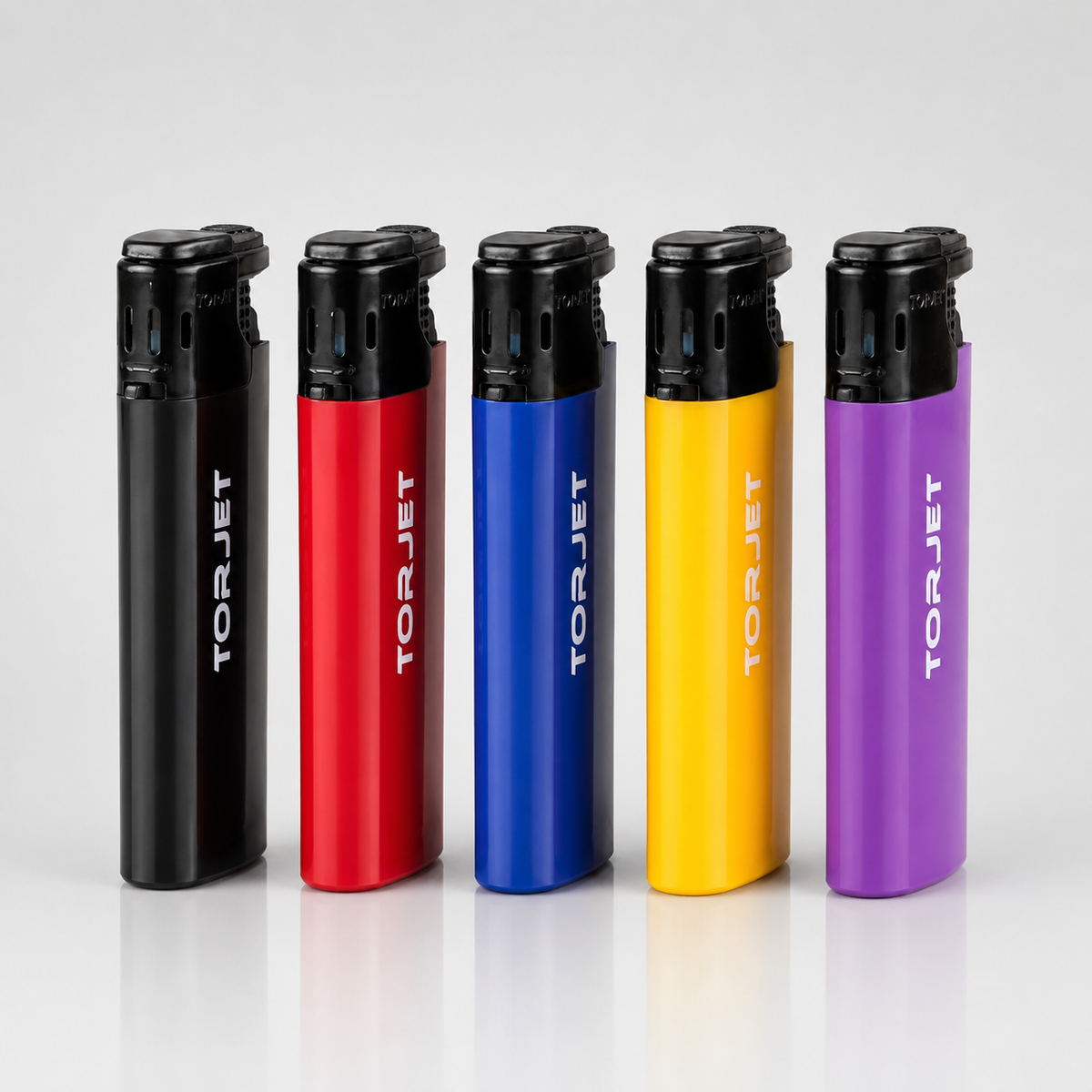 Five TOR JET portable lighters in black, red, blue, yellow, and purple, lined up side-by-side on a reflective white surface against a light gray background.