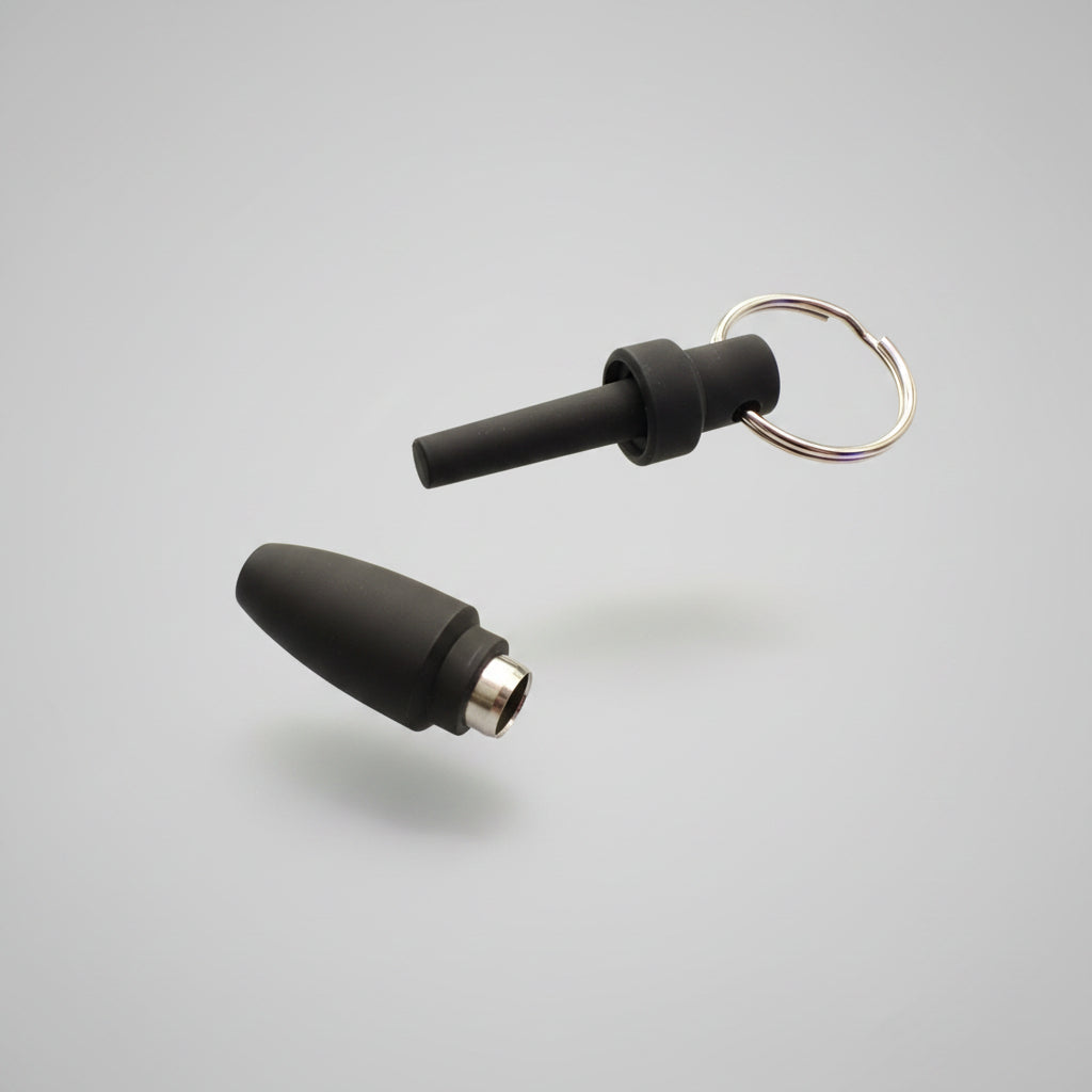 Two black silicone cigar punch cutters tips with metal connectors and a keyring, placed on a white background 