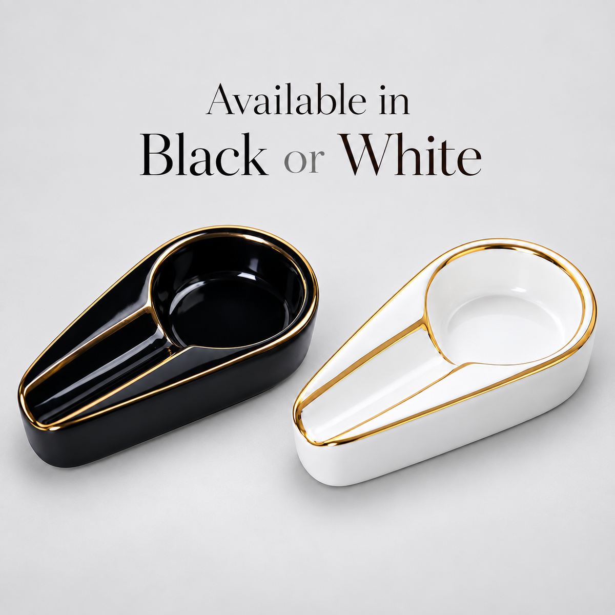 Two modern teardrop-shaped ceramic ashtrays shown on a light gray background, one glossy black with gold trim and one glossy white with gold trim. Text above reads 'Available in Black or White'.