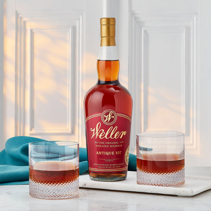 Weller whiskey bottle with two glasses on a marble surface