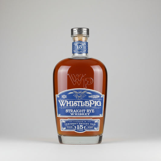 A bottle of Whistlepig Straight Rye Whiskey in a 15-year Vermont Estate Oak style, featuring amber liquid, a blue and white label, and a silver cap on a white background.