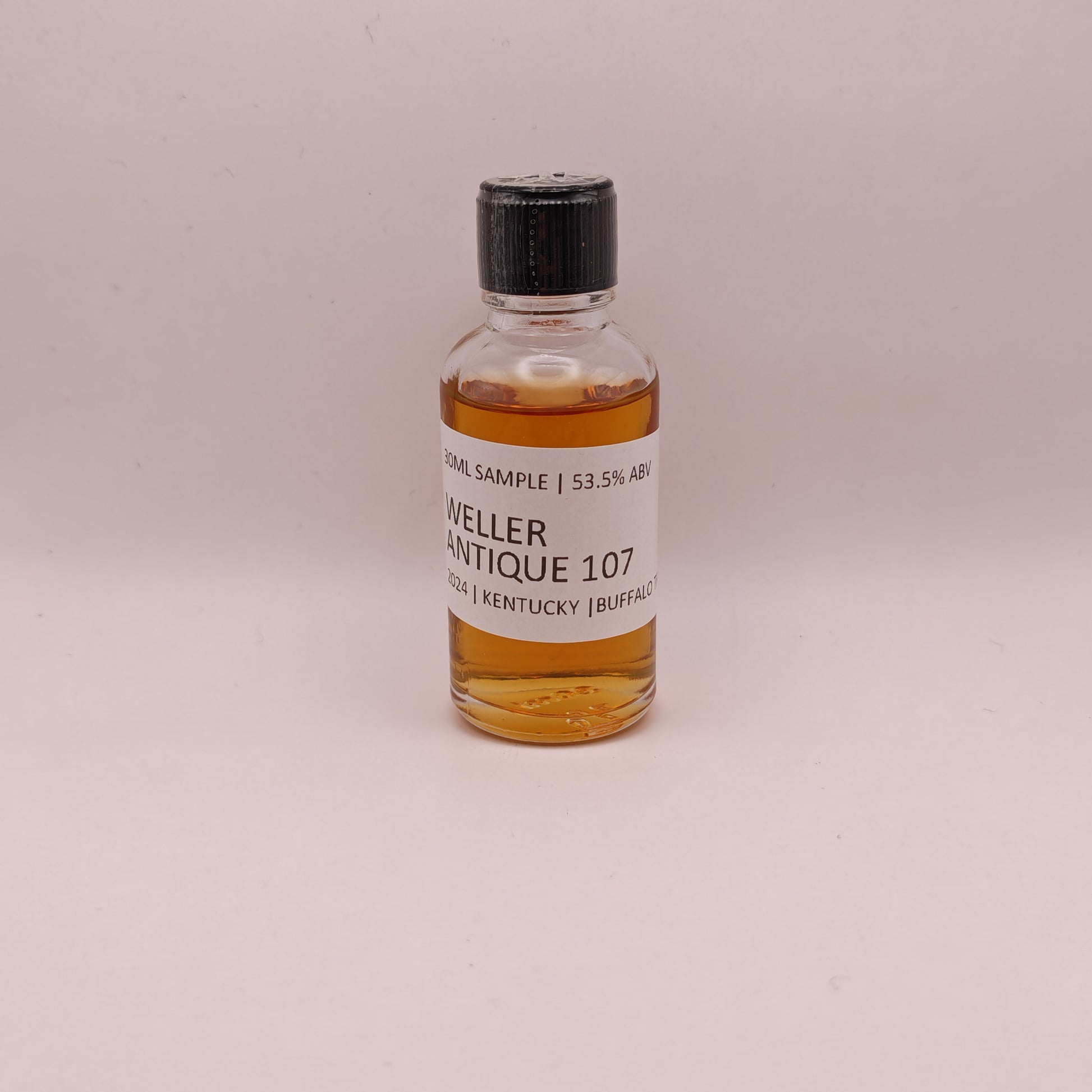 Small bottle of Weller Antique 107 whiskey sample on a light gray background