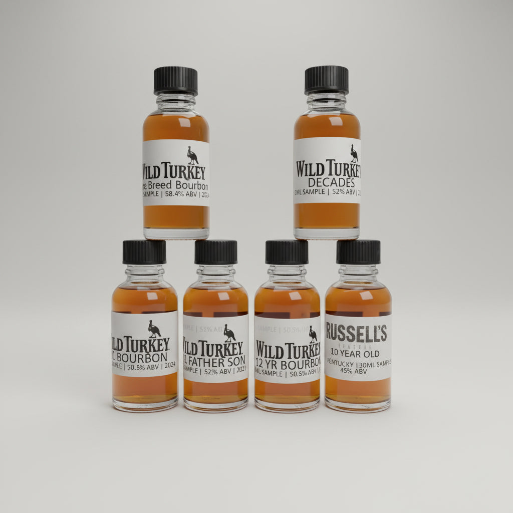 Collection of Wild Turkey bourbon bottles on a bar counter with a blurred bar background.