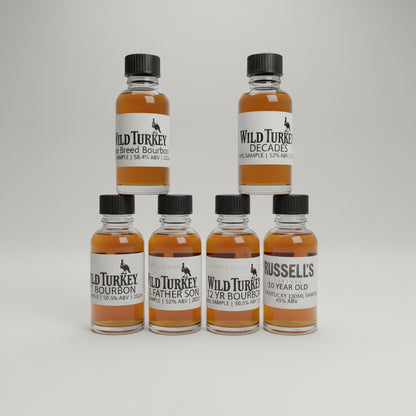 Collection of Wild Turkey bourbon bottles on a bar counter with a blurred bar background.