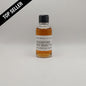 Small bottle of Woodford Reserve whiskey sample on a gray background
