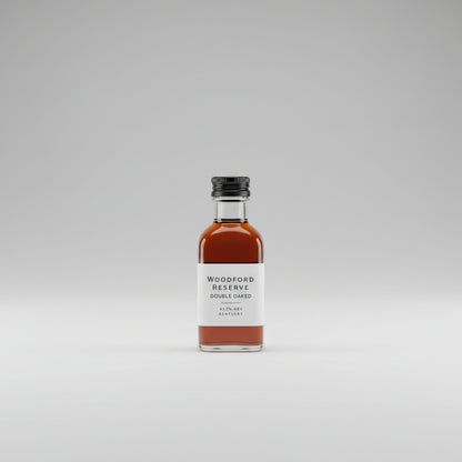 Bottle of Woodford Reserve Double Oaked bourbon on a reflective surface with a bar setting in the background.