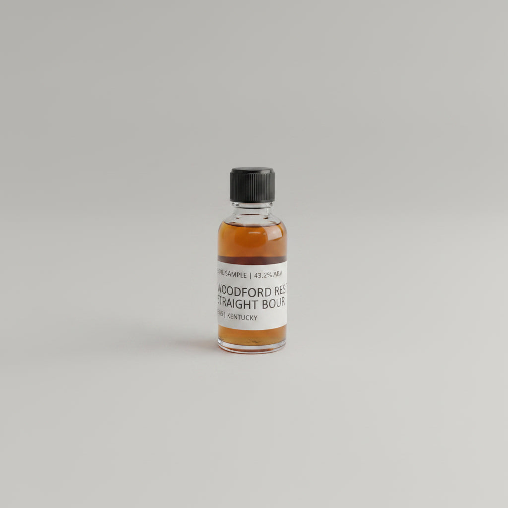 Small bottle of Woodford Reserve bourbon on a beige background