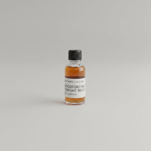Small bottle of Woodford Reserve bourbon on a beige background