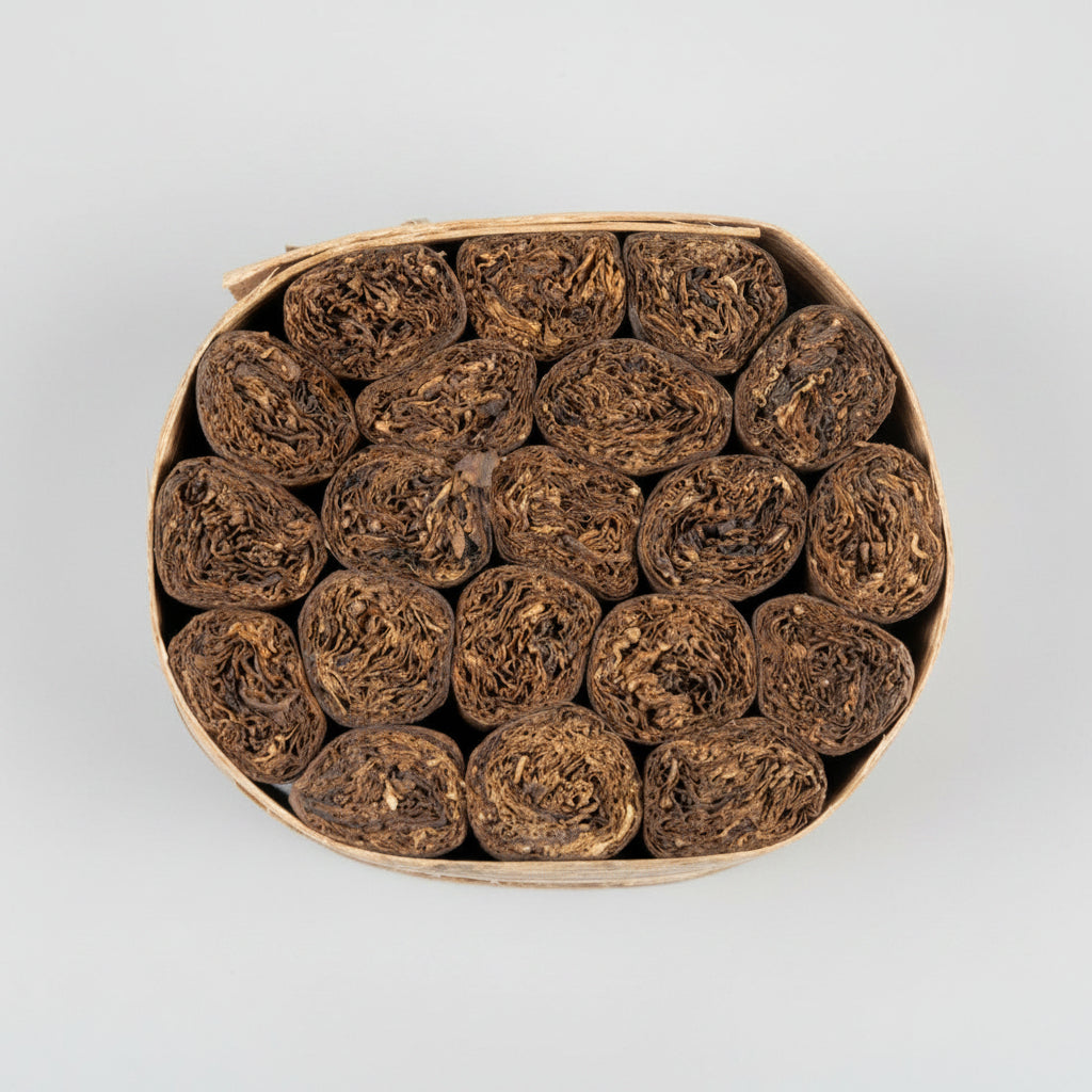 close up of a bundle iof Cigars in a bannana leaf on a white background