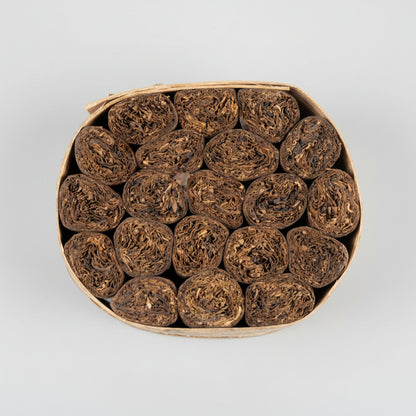 close up of a bundle iof Cigars in a bannana leaf on a white background