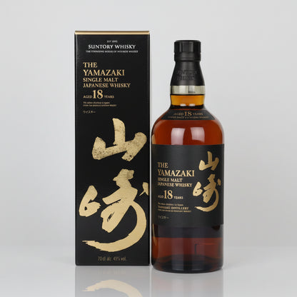 A bottle of Suntory Whisky The Yamazaki Single Malt Japanese Whisky 18 Years next to its black and gold packaging box, set against a plain white background.